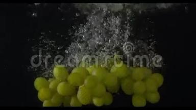 一串绿色的葡萄在镜头中央潜入水中，黑色背景，慢动作，米/秒